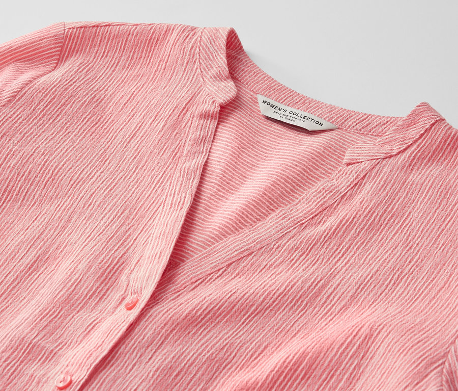 Detailaufnahme einer gestreiften, korallenroten Longtunika.