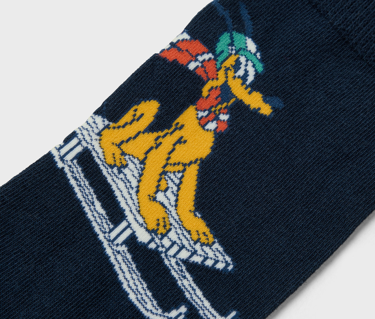 Detailaufnahme einer marineblauen Socke mit einer gelben Comicfigur, die Ski fährt.