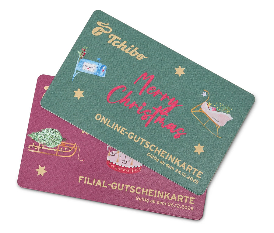 Zwei Geschenkkarten mit Weihnachtsmotiven liegen übereinander. Die grüne Karte oben trägt die Aufschrift "Frohe Weihnachten" und zeigt Abbildungen von Schlitten und einem Briefkasten. Die untere Karte ist rosa und zeigt ein Bild von einem Weihnachtsbaum auf einem Schlitten. Eine der Karten ist ein Tchibo Adventskalender.