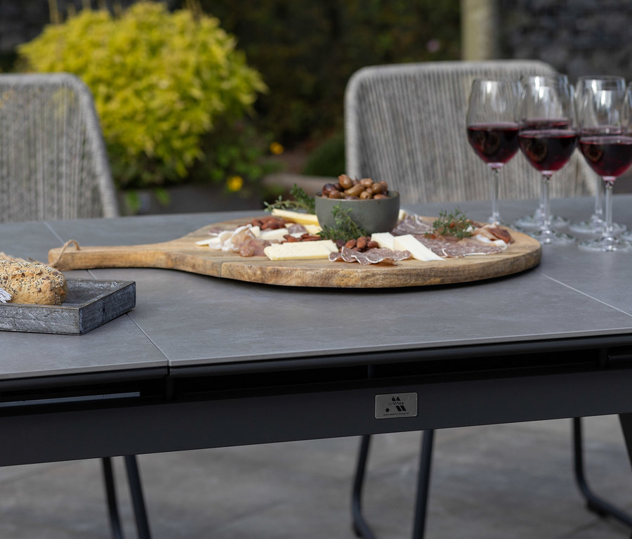 Auf dem DeVries Ausziehtisch 160/210, hellgrau stehen Speisen und Getränke.