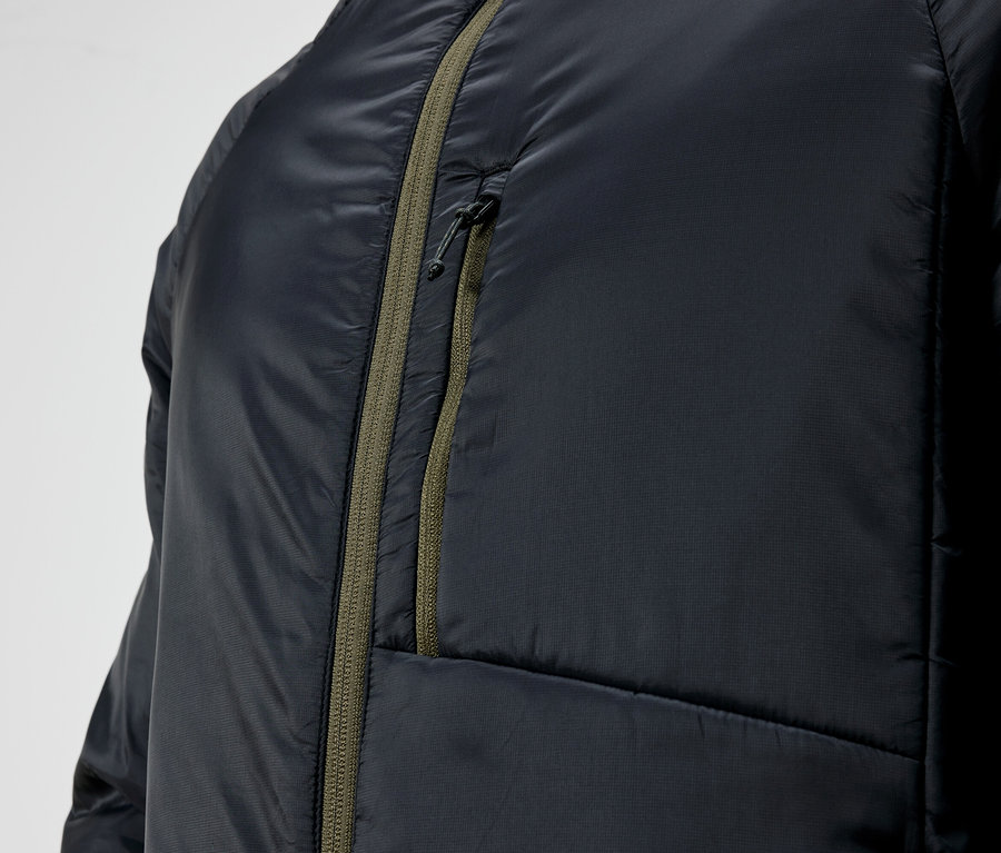 Detailaufnahme einer schwarzen Steppjacke mit grünem Reißverschluss.