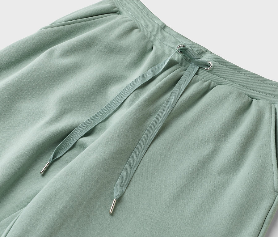 Nahaufnahme einer hellgrünen Jogginghose mit Kordelzug.