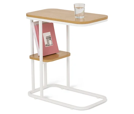 Ein Beistelltisch mit Holzplatte, weißem Gestell, einem Wasserglas und Büchern.