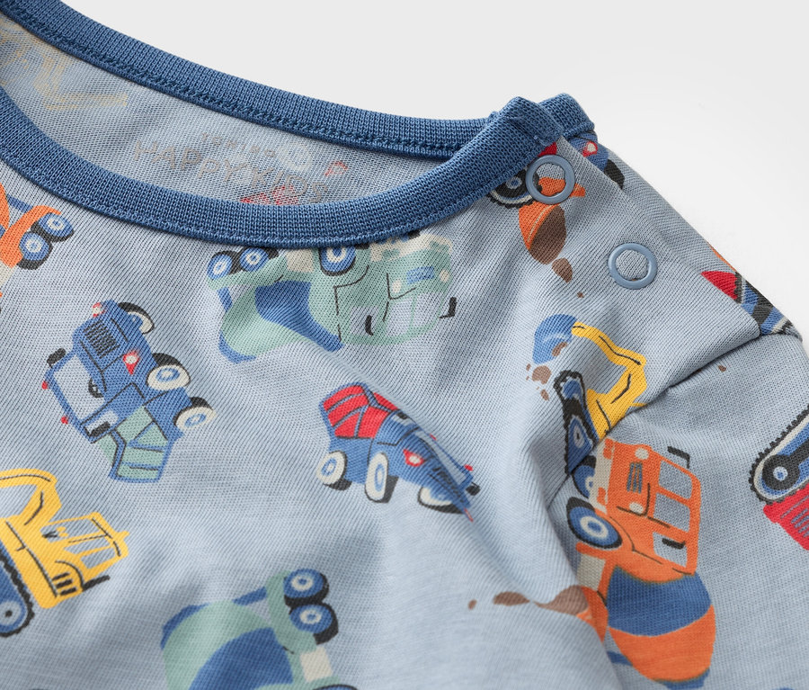 Nahaufnahme eines hellblauen Stoffes mit verschiedenfarbigen Fahrzeugen.
