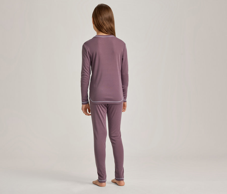 Eine Person von hinten, die ein langärmliges Oberteil und eine lange Hose in Mauve trägt und barfuß auf hellem Hintergrund steht.