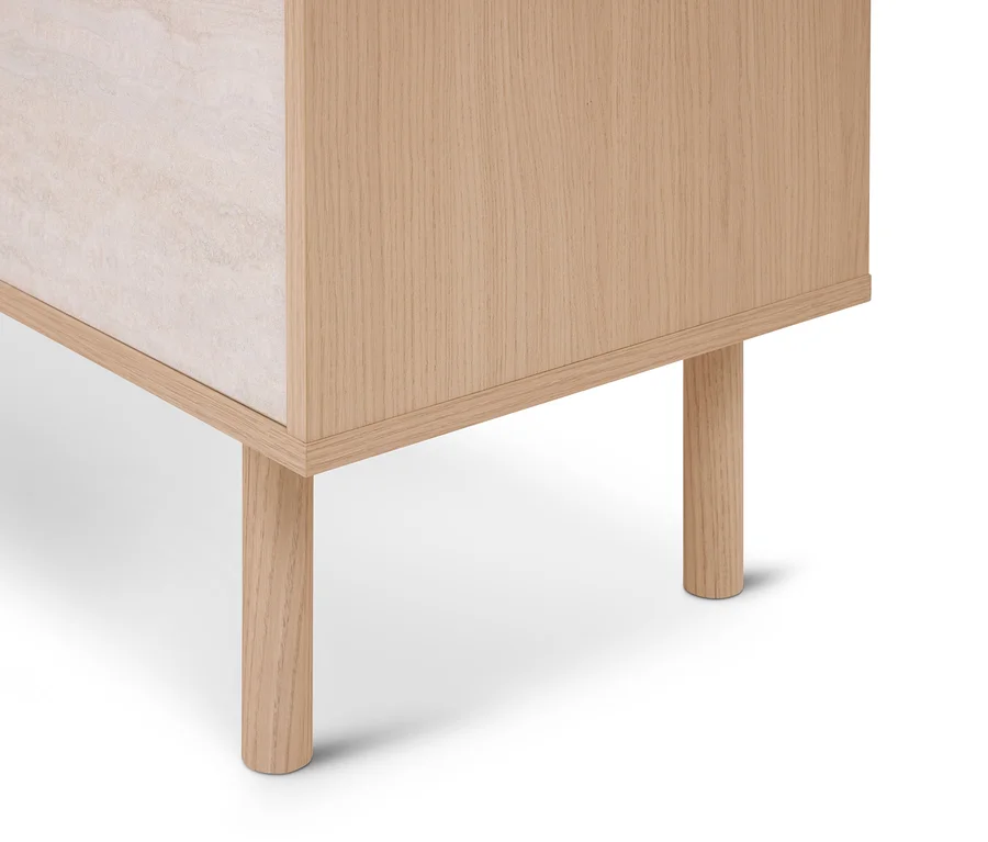 Untere Ecke eines hellen Holzschranks mit runden Holzbeinen und einer hellen, strukturierten Seitenplatte.