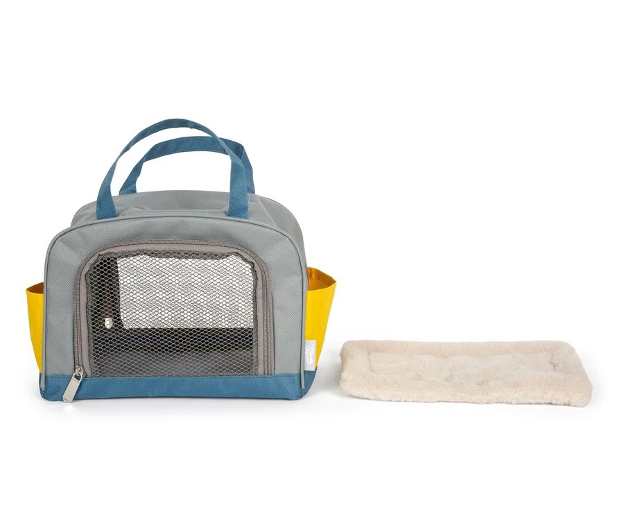 Graue small foot Hund mit Tasche und Pflege-Set mit blauen Details und gelben Taschen, sowie eine beige Unterlage.