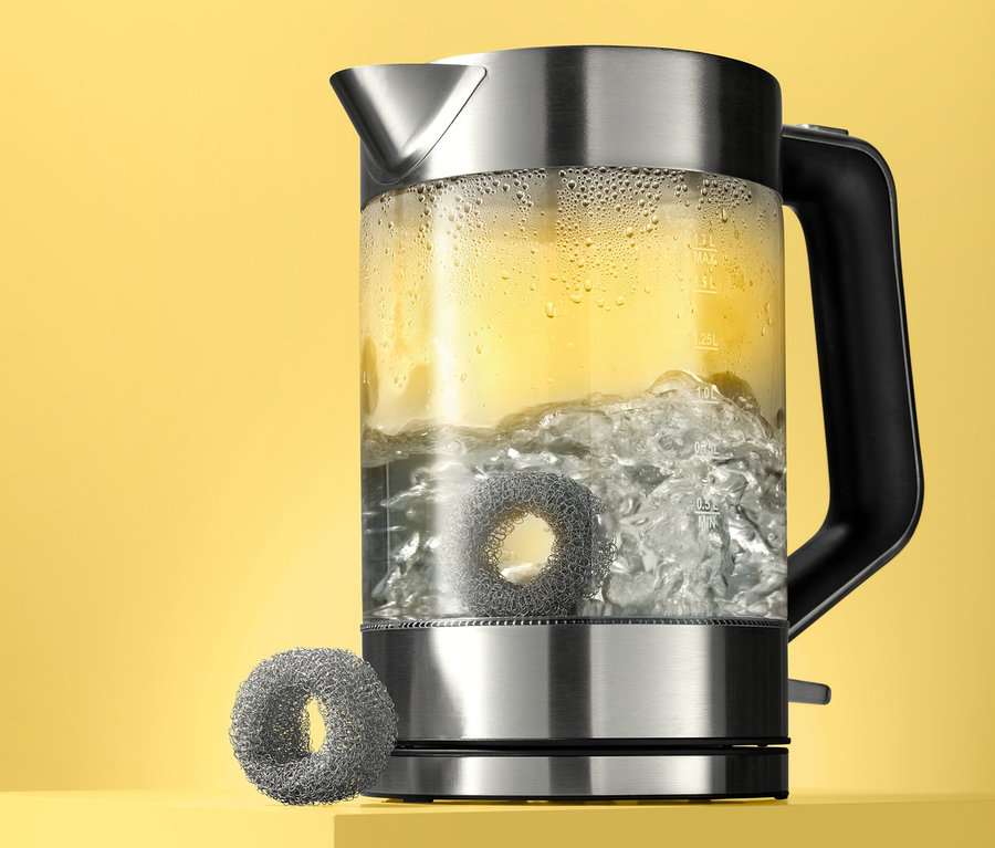Wasserkocher mit kochendem Wasser und zwei Kalkfängern.