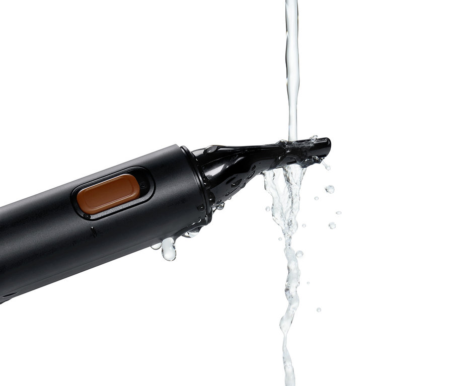 Wasser läuft über einen schwarzen Präzisions-Gesichtshaartrimmer.
