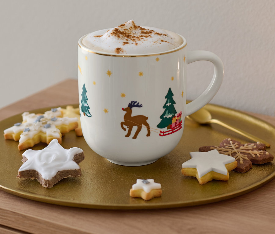 Auf einem goldenen Tablett stehen ein Jumbobecher mit Glanzgolddekor, ein Cappuccino und Kekse.