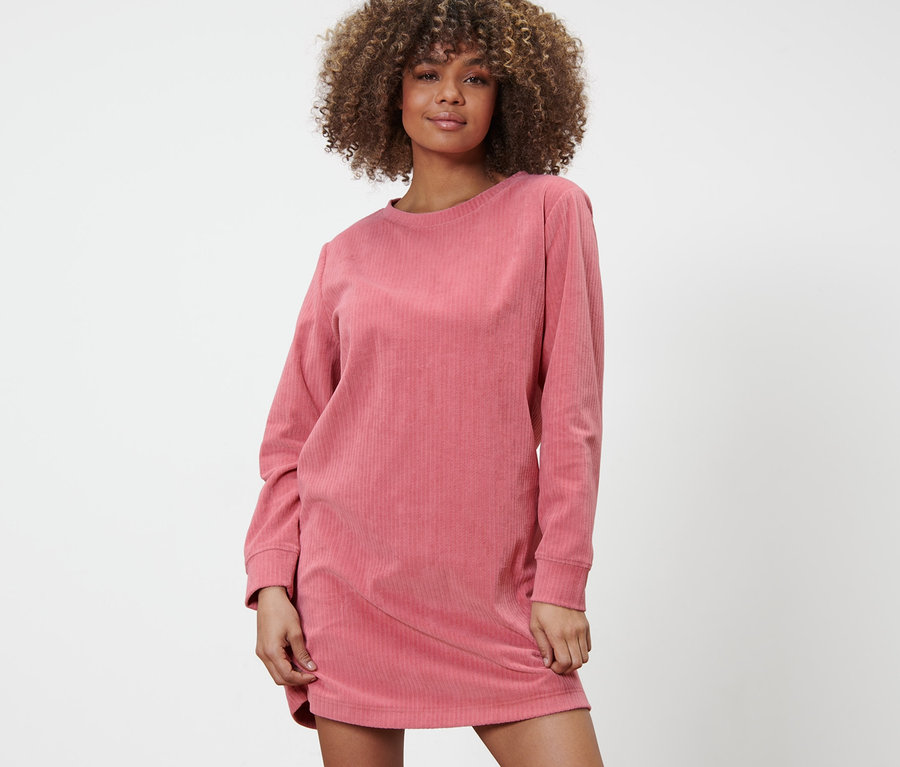 Frau posiert in einem Lounge-Kleid.