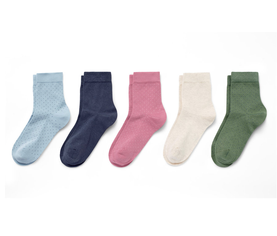 Auf einem weißen Hintergrund liegen fünf Paar Socken: hellblaue mit dunkelblauen Punkten, dunkelblaue, rosafarbene mit weißen Punkten, cremefarbene und olivgrüne mit dunkelgrünen Punkten.