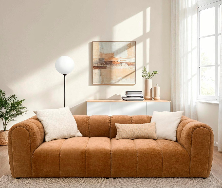 Ein braunes Sofa mit zwei beige Kissen in einem Wohnzimmer.