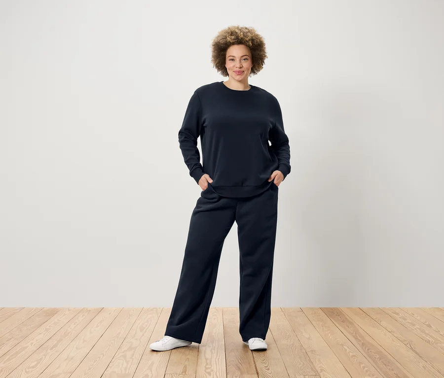 Frau posiert in dunkelblauer Sweathose.