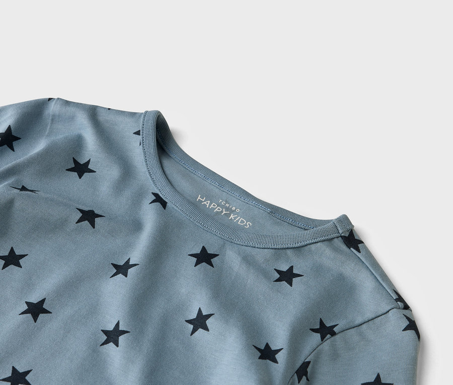 Nahaufnahme eines hellblauen HAPPY KIDS T-Shirts mit schwarzen Sternen.