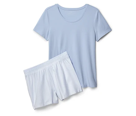 Ein hellblaues T-Shirt und Shorts mit blauen Streifen liegen auf einem weißen Hintergrund.