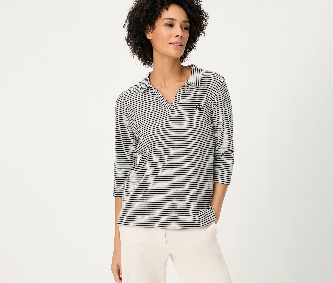 Frau trägt gestreiftes Olsen Polo-Shirt mit Dreiviertelärmeln und helle Hose.