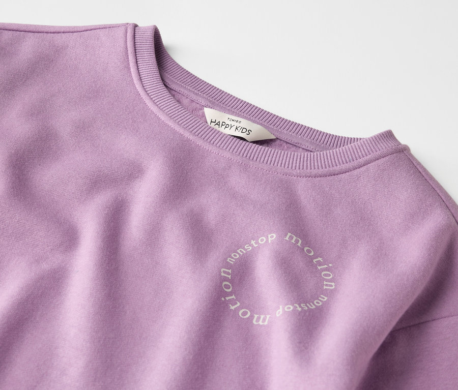 Nahaufnahme eines lila Sweatshirts mit der Aufschrift "nonstop motion".