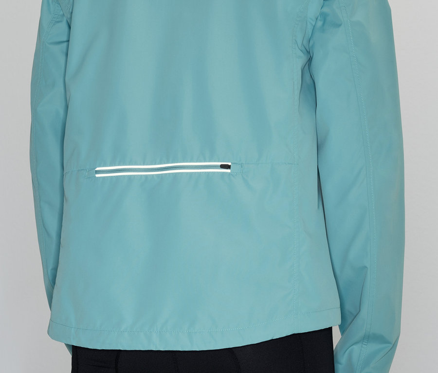Rückansicht einer Person, die eine hellblaue Jacke mit einer horizontalen reflektierenden Tasche trägt.