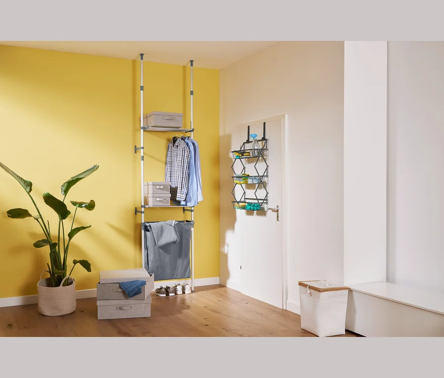 Im Zimmer stehen ein Teleskopregal mit Wäschebeutel, ein XL-Ordnungsboxen-Set und faltbare Tür-Hängekörbe.