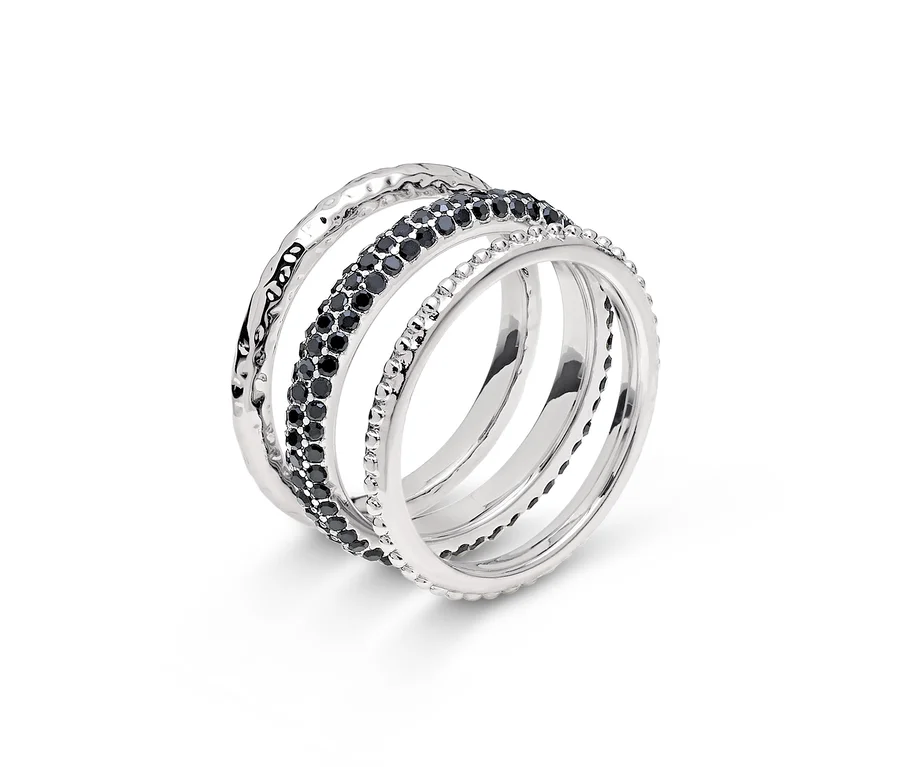 Detailaufnahme eines silbernen Rings mit vier Bändern, eines davon mit schwarzen Steinen.