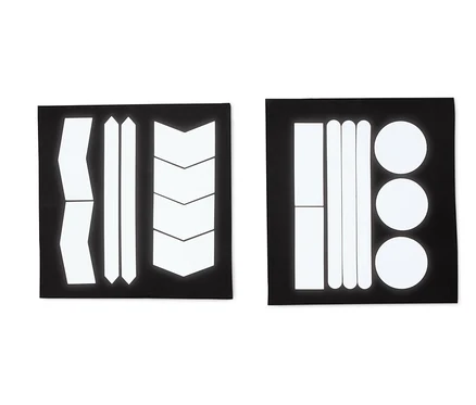 Zwei schwarze Bögen mit reflektierenden Aufklebern in verschiedenen Formen: Streifen, Pfeile und Kreise.