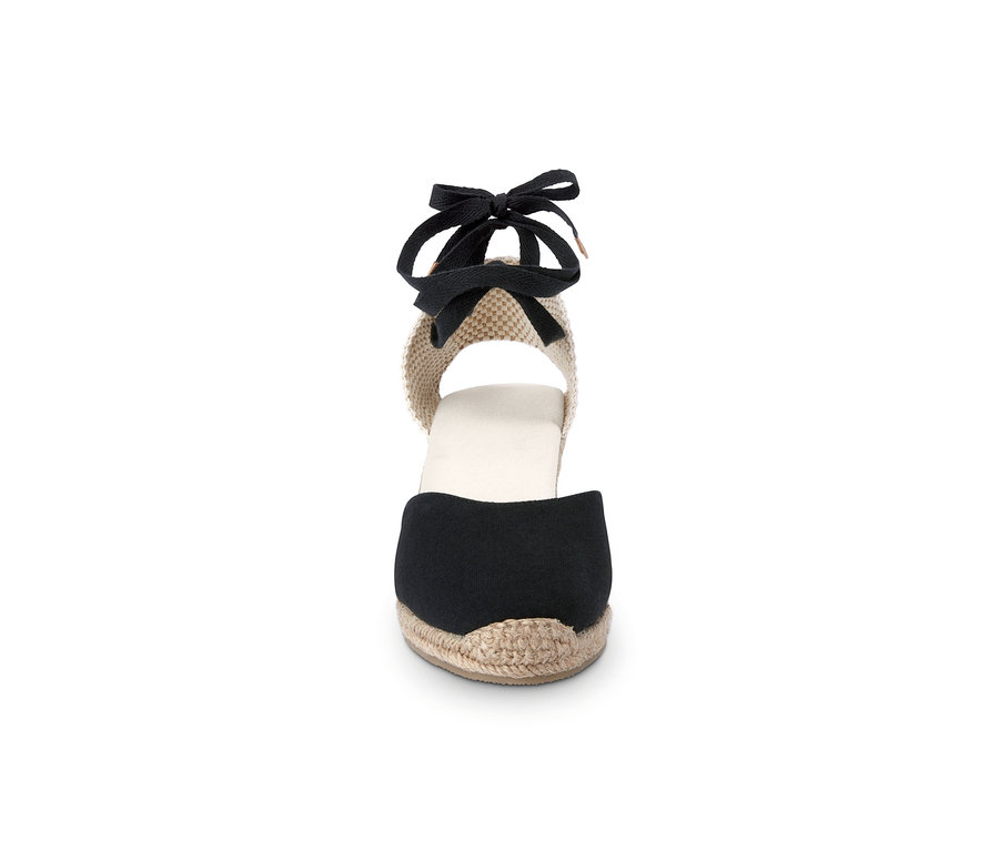 Detail einer Damen-Espadrille mit Keilabsatz und schwarzem Band.