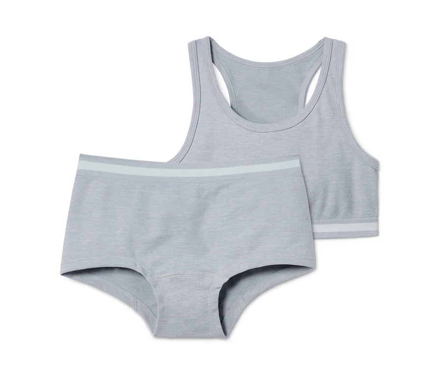 Ein graues Seamless-Bustier und -Panty, Set liegt auf einem weißen Hintergrund.