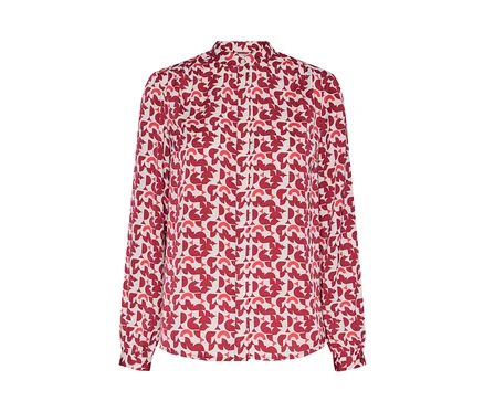 Detail einer bedruckten Bluse mit rotem geometrischen Muster.