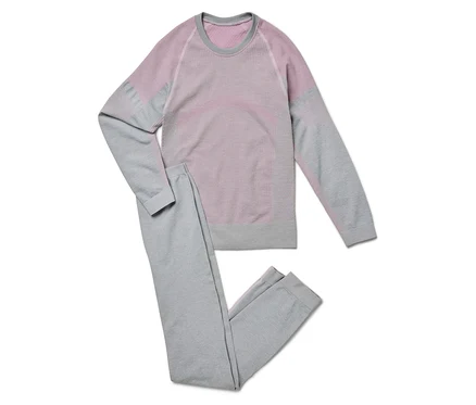 Graue Trainingshose und langärmeliges Shirt mit rosa Details liegen auf einem weißen Hintergrund.