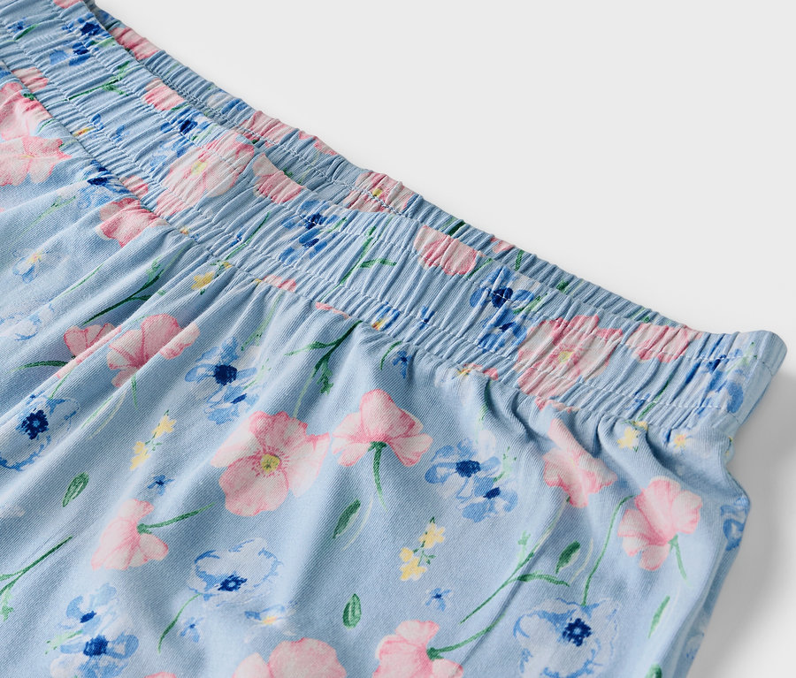 Detail einer hellblauen Hose mit Blumenmuster und elastischem Bund.