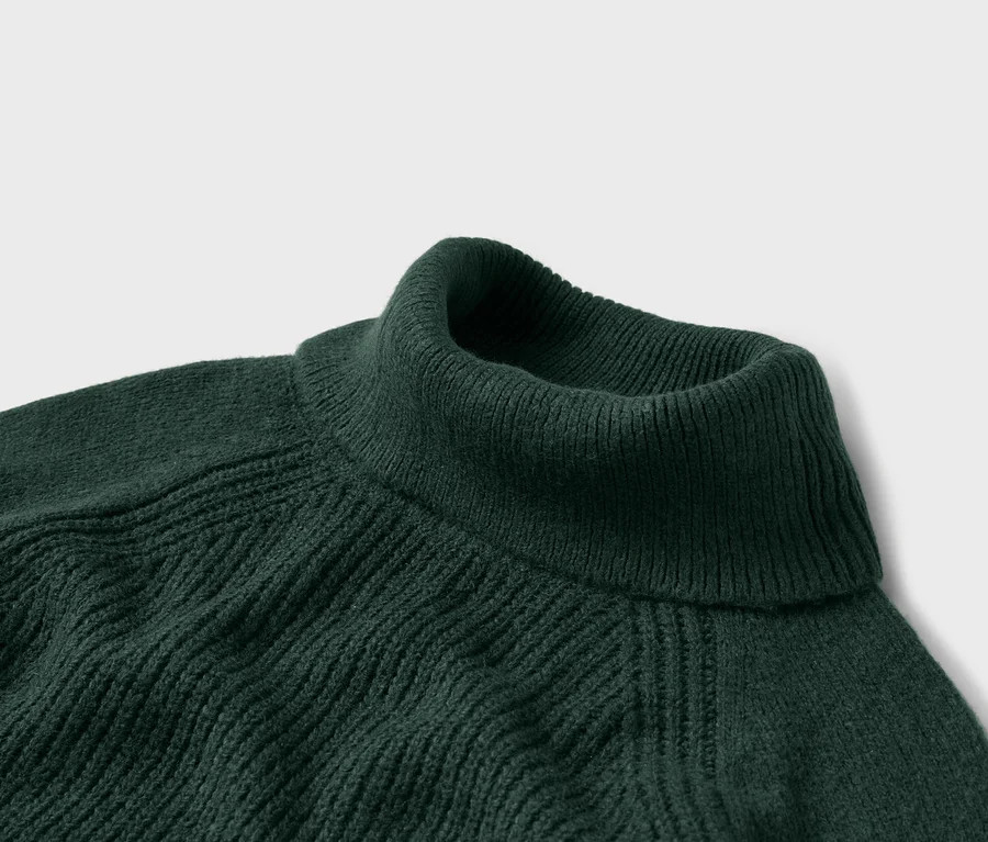 Detailaufnahme eines dunkelgrünen Rollkragenpullovers mit Rippstrickmuster.