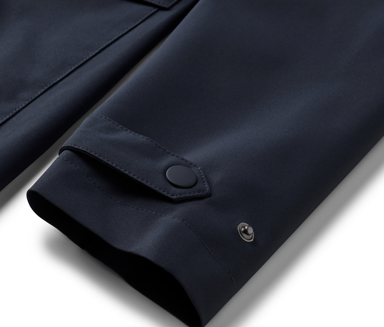 Detailansicht Ärmel eines blauen Regentrenchcoats.