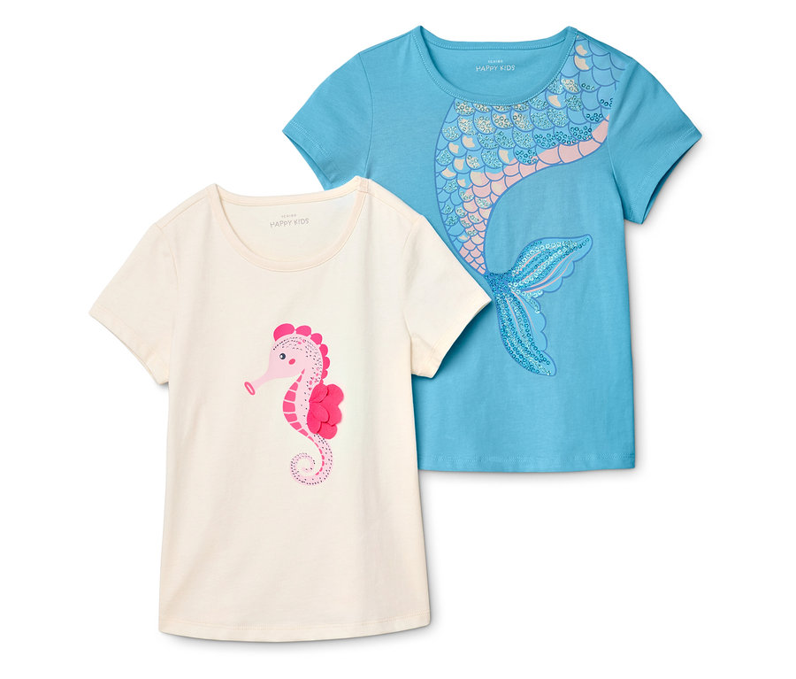 Zwei T-Shirts liegen übereinander. Das eine ist hellbeige mit einem rosa Seepferdchen, das andere ist hellblau mit einem Meerjungfrau-Motiv.