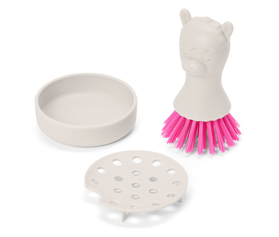 Ein beiger Spülbürstenhalter mit Abtropffläche und eine Spülbürste mit rosa Borsten und einem Griff in Form eines Lamas sind zu sehen.