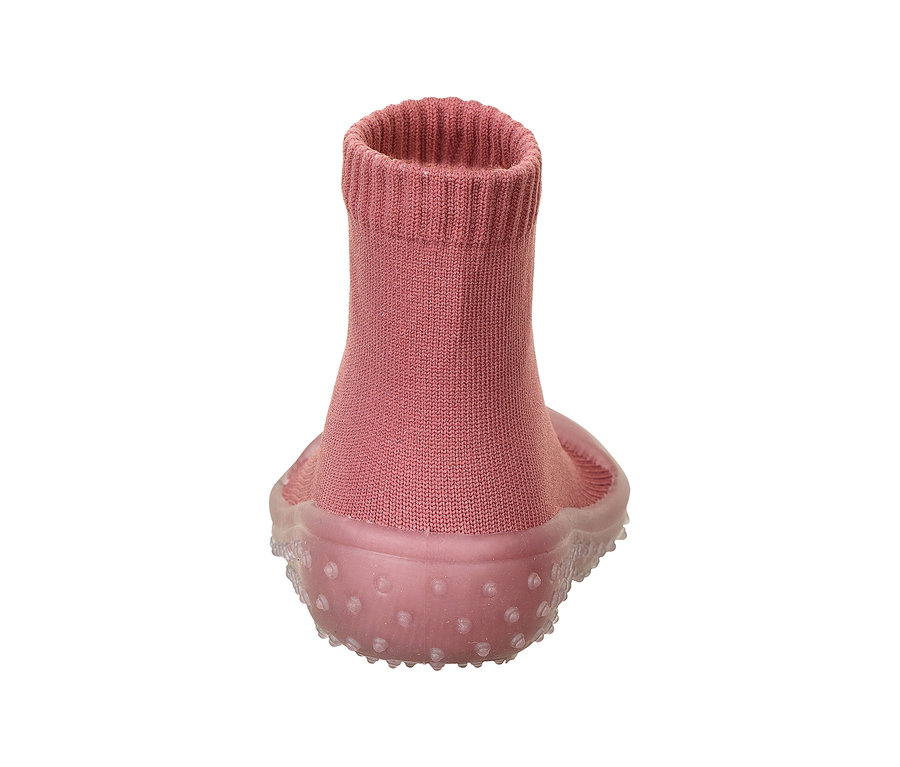 Ein einzelner rosafarbener Babyschuh mit gestricktem Obermaterial und einer transparenten, genoppten Gummisohle, von hinten gesehen.