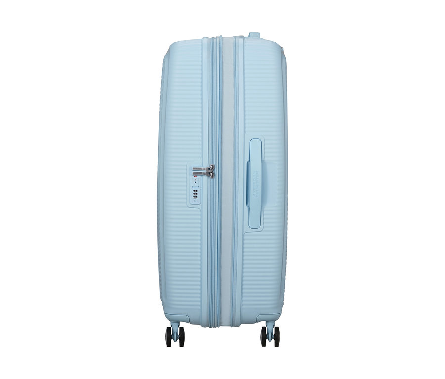 Hellblauer American Tourister Hartschalen-Koffer »Soundbox« Spinner, groß, mit Reißverschluss, Zahlenschloss und vier Rollen, von der Seite stehend.
