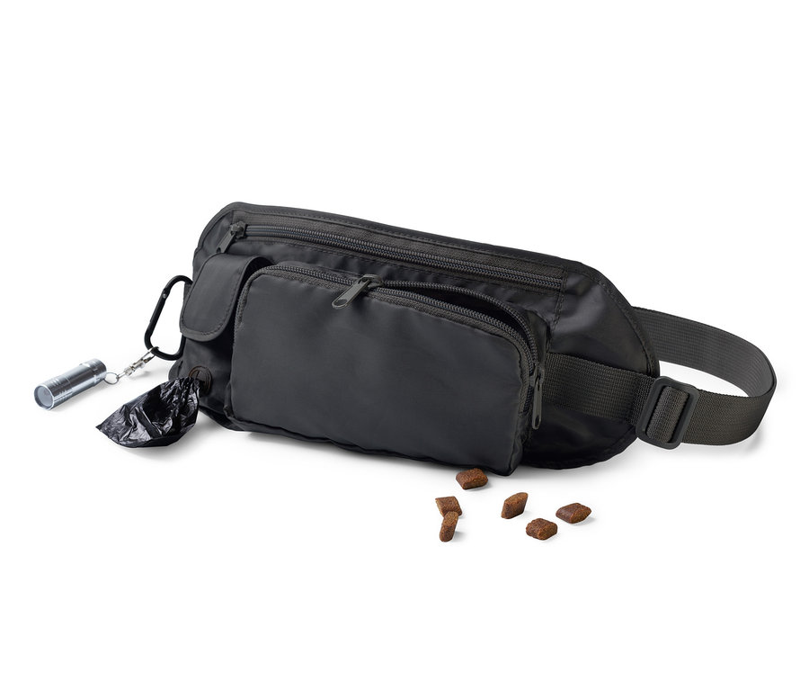 Eine schwarze Hunde-Gassibeutel-Tasche liegt auf einem weißen Hintergrund neben Hundefutter.