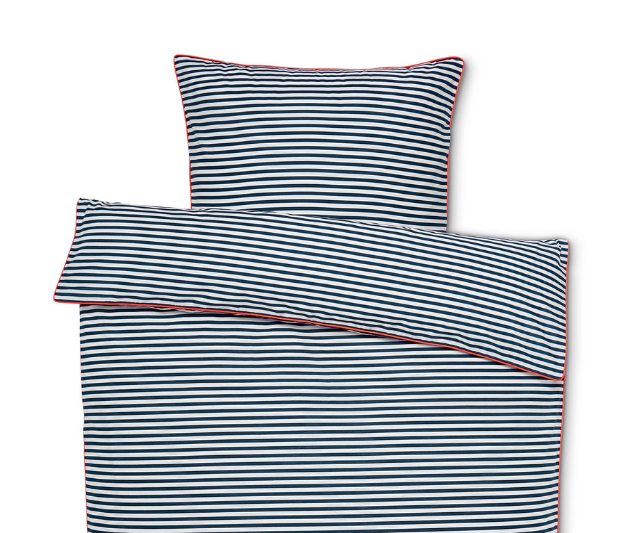 Draufsicht auf eine ausgebreitete Renforcé-Bettwäsche mit blauen und weißen Streifen und roter Paspel.