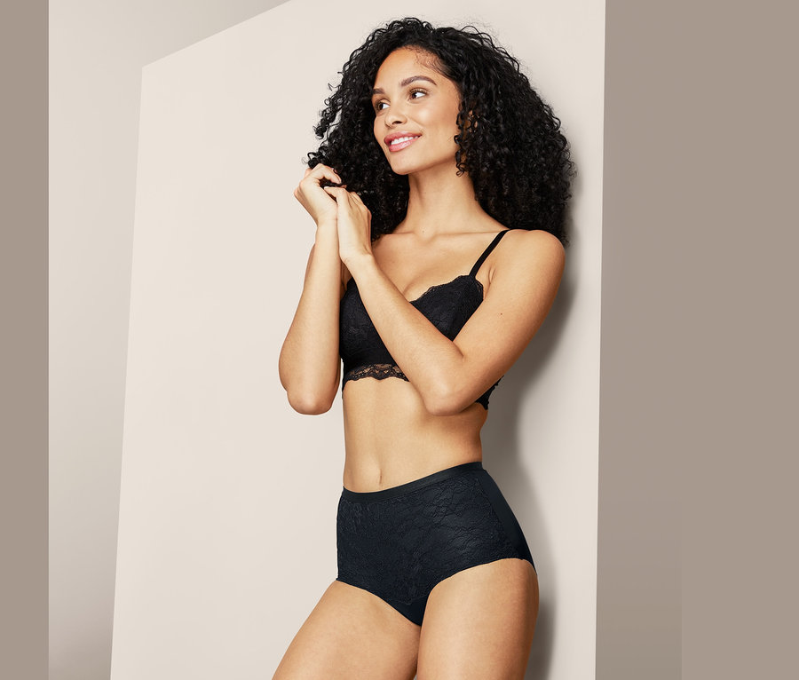 Frau posiert in schwarzem Spitzen-BH und Bodyforming-Panty.