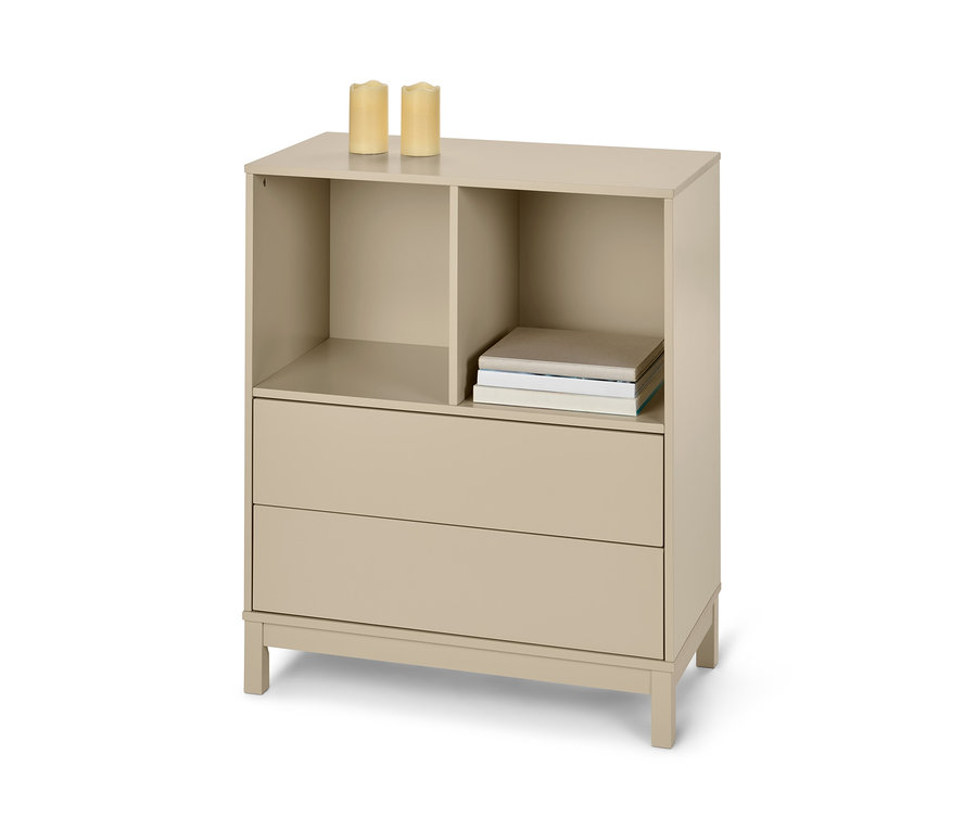 Beige Hochkommode mit 2 Schubladen und offenen Regalen, auf der Oberseite stehen zwei Kerzen und liegen Bücher.