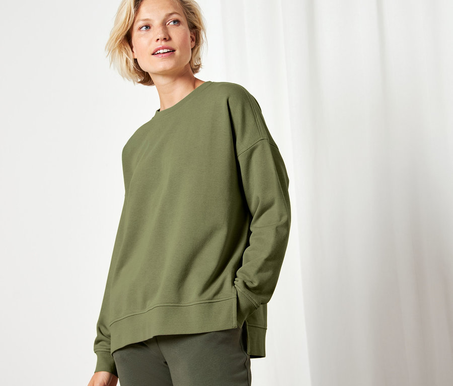 Frau trägt grünes Sweatshirt.