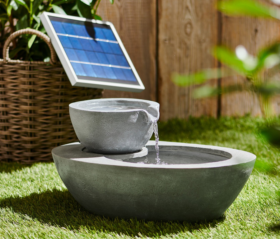 Grauer Solar-Gartenbrunnen mit zwei Schalen auf Gras.