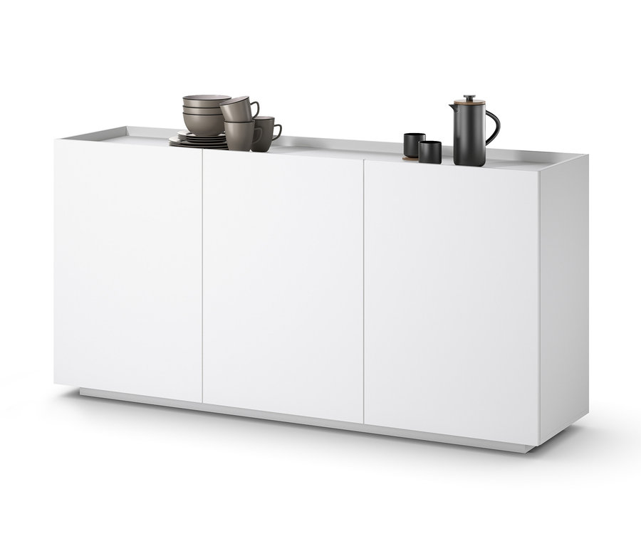 Ein weißes Sideboard mit drei Türen. Auf dem Sideboard stehen Tassen und eine Kanne.