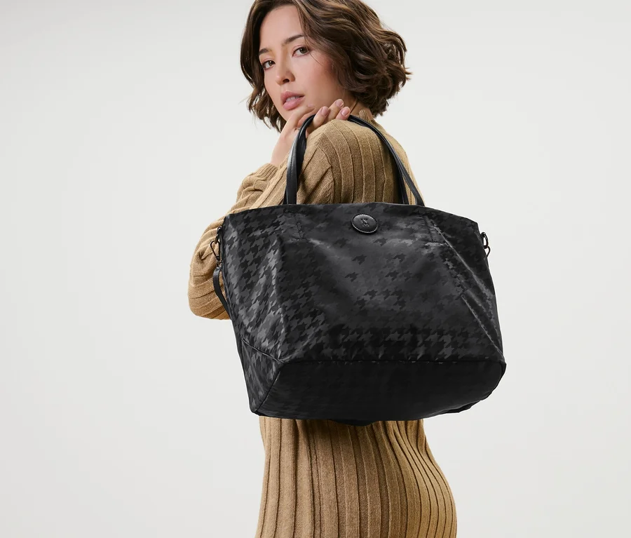 Frau posiert mit schwarzem Shopper.