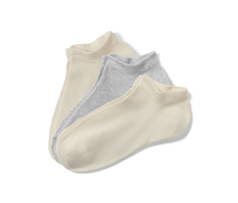 Nahaufnahme von drei Paar Kinder-Sneakersocken in Beige und Hellgrau.