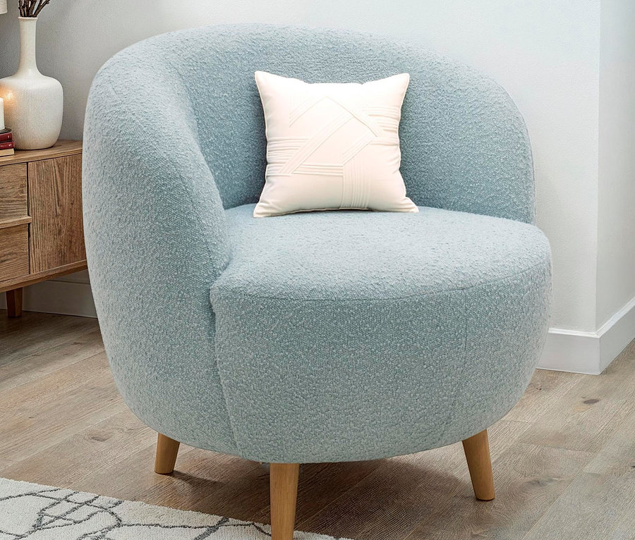 Hellblauer Sessel mit cremefarbenem Kissen auf dem Sitz.