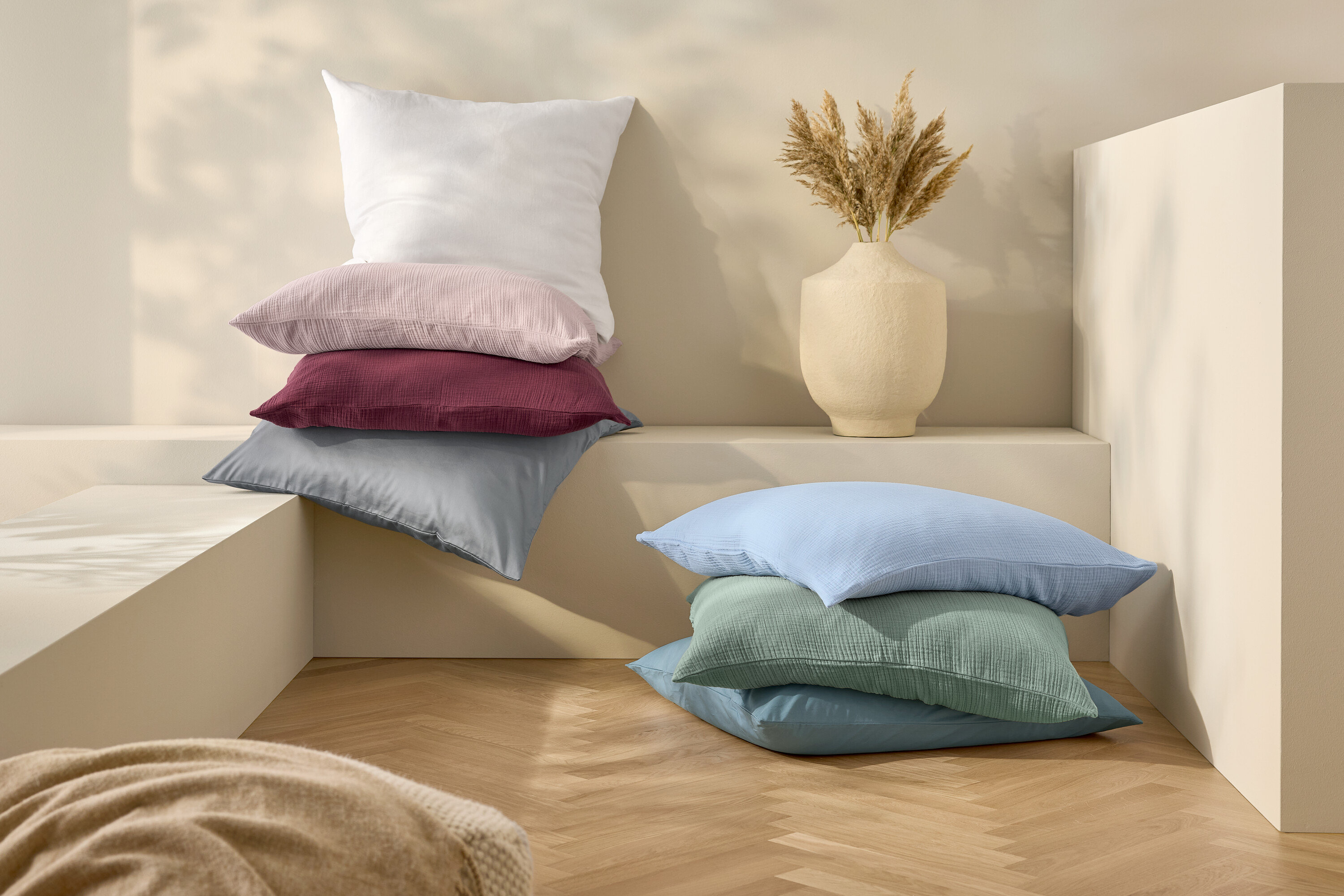 Gestapelte Kissen und Leinen-Bettwäsche, weiß, Normalgröße.