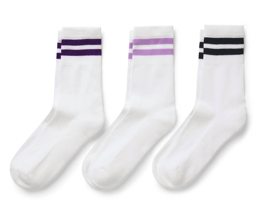 Drei weiße Socken mit farbigen Streifen oben.