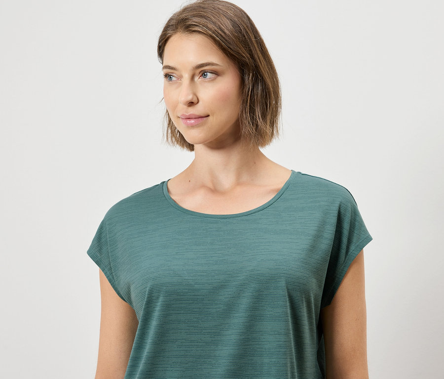 Frau trägt ein grünes T-Shirt.